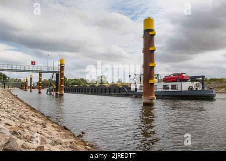 Una nave della via navigabile interna piena di carbone, guida verso la serratura vicino alla città di Langwedel sulla parte centrale del fiume Weser. Foto Stock