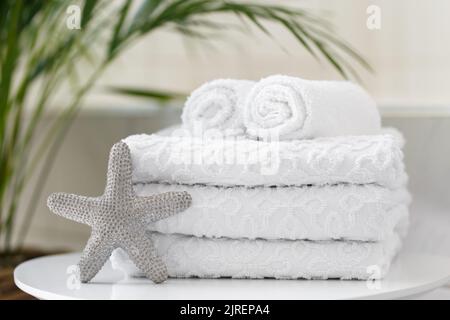 Asciugamani bianchi arrotolati in bagno o in un salone termale, primo piano Foto Stock