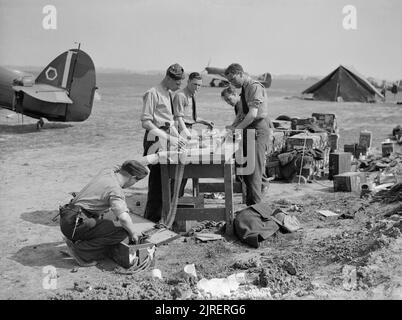 Royal Air Force- Francia, 1939-1940. Personale di terra e gli armaioli ricarica nastri di munizioni con proiettili 303 da Hawker Hurricane Mark è di n. 85 Squadron RAF a Lille-Seclin. Foto Stock