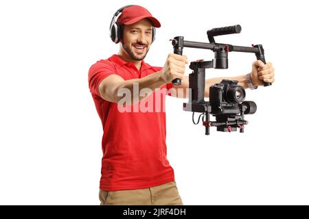 Uomo con cuffie che azionano uno stabilizzatore della fotocamera gimbal isolato su sfondo bianco Foto Stock