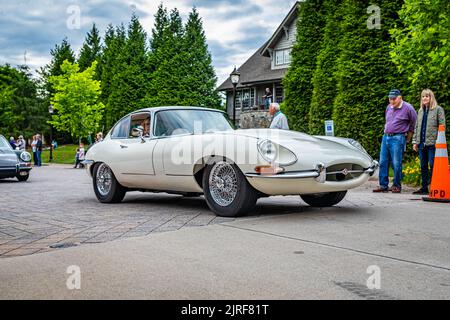 Highlands, NC - 10 giugno 2022: Vista dall'angolo anteriore in prospettiva bassa di una Jaguar e-Type 1 Coupé del 1964 che esce da una fiera automobilistica locale. Foto Stock