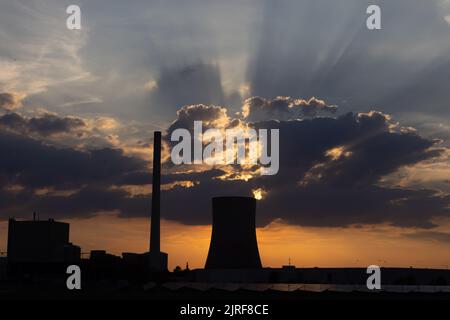 Petershagen, Germania. 23rd ago, 2022. Vista della centrale a carbone duro di Heyden contro il sole tramontato. Per risparmiare gas naturale, un'altra centrale a carbone proveniente dalla riserva tedesca sta per essere riavviata. Si tratta della centrale elettrica di Heyden a Petershagen, nella Renania settentrionale-Vestfalia, al confine con la bassa Sassonia. Secondo l'operatore Uniper, il rientro sul mercato è previsto dal lunedì prossimo fino alla fine di aprile 2023. Credit: Friso Gentsch/dpa/Alamy Live News Foto Stock