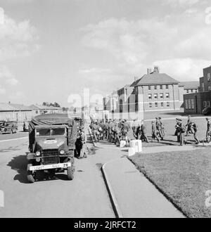 US Army University, Shrivenham (Inghilterra, Regno Unito, 1945 gli studenti e il personale dell'esercito statunitense University, Shrivenham, iniziare a coda sotto il sole per il trasporto che li porterà in Stratford-upon-Avon per vedere uno spettacolo al Shakespeare Memorial Theatre. Secondo la didascalia originale, due viaggi busloads in Stratford ogni notte. Molti camion e jeep può essere visto come un British telefono rosso scatola. Foto Stock