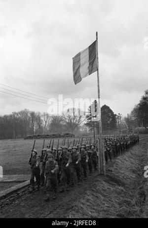 Commandos belga in materia di formazione, UK, 1945 Una società del secondo battaglione, 2° Brigata belga marzo passato la bandiera belga durante la loro formazione Commando, da qualche parte in Gran Bretagna. Foto Stock