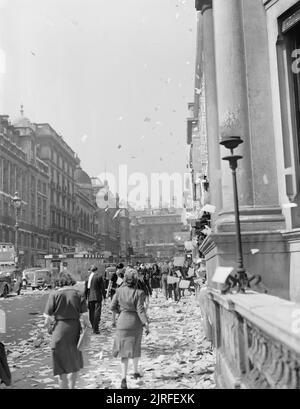 La Gran Bretagna ascolta la notizia della fine della guerra Jap- celebrando la vittoria in Giappone, Londra, Inghilterra, Regno Unito, c 15 agosto 1945 i civili a piedi tra le pile dei residui di carta che sono stati gettati, 'ticker tape'-stile, dalle finestre degli uffici, sul Lower Regent Street, Londra, per celebrare la firma della pace con il Giappone. Più carta può essere visto che fluttua in giù sul marciapiede e strada: molti veicoli sembrano essersi fermato. Sembra che questa fotografia è stata presa sul Lower Regent Street, guardando indietro verso Piccadilly Circus. In mezzo alla strada (a sinistra della fotografia), una superficie in mattoni shelte Foto Stock