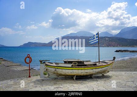 Altes Fischerboot mit griechischer Flagge am Strand von Ierapetra, der suedlichsten Stadt Griechenlands, Kreta, Griechenland, Europa | Old fishing boa Foto Stock