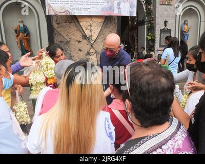 Malabon, Filippine. 24th ago, 2022. Un uomo acquista 'sampaguita' o il fiore di gelsomino arabo dai venditori fuori della chiesa. I residenti della città di Malabon osservano la festa di San Bartolomeo o San Bartolome, uno dei dodici apostoli di Gesù Cristo ogni 24th agosto dell'anno. I residenti locali vanno in chiesa per ascoltare la Santa Messa o la 'Misa Concelebrada' o la messa concelebrata da più di dieci sacerdoti, per pregare e ringraziare per le benedizioni che hanno ricevuto. Credit: SOPA Images Limited/Alamy Live News Foto Stock