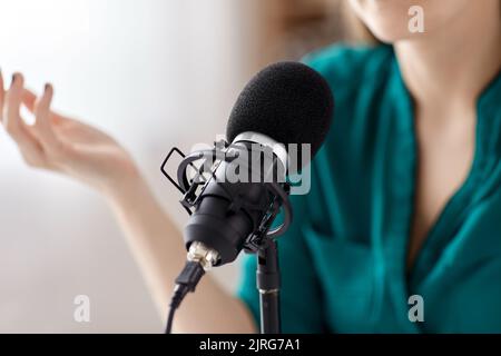 Donna con microfono podcast di registrazione in studio Foto Stock