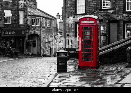 Una cassetta telefonica rossa K6 su sfondo monocromatico a Haworth, Yorkshire, Inghilterra. Foto Stock