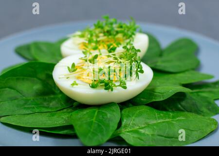 Uova sode e fresche accanto a verdi croccanti freschi. Insalata in stile moderno Foto Stock