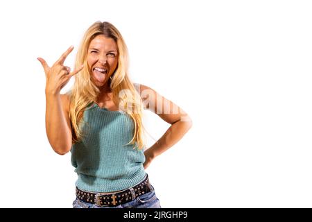 Motivata e sorridente ragazza rocker alza le dita nel segno rocker. Foto Stock