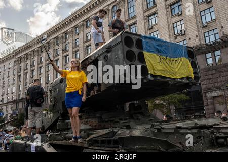 21 agosto 2022, Kiev, Kiev Oblast, Ucraina: Una donna prende un selfie mentre la gente sale sull'esposizione di un veicolo russo distrutto del sistema di lancio del multirazzo (MLRS) sulle strade di Kiev. Dedicato alla prossima Giornata dell'Indipendenza dell'Ucraina, e quasi 6 mesi dopo l'invasione su vasta scala dell'Ucraina il 24 febbraio, la capitale del paese Kyiv tiene una mostra sulla strada principale di Khreschaytk Street che mostra numerose attrezzature militari distrutte, Carri armati e armi dalle forze armate della Federazione Russa (AFRF). Come la piena invasione russa dell'Ucraina iniziato il 24 febbraio, Foto Stock