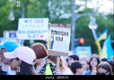 Berlino, Germania. 24th ago, 2022. "Silence kills” è scritto su un cartello tenuto da un dimostratore alla marcia di protesta dell'associazione 'Vitsche' per la Giornata dell'Indipendenza dell'Ucraina e contro la guerra. Credit: Annette Riedl/dpa/Alamy Live News Foto Stock