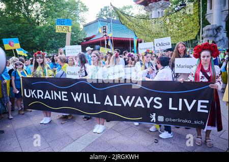 Berlino, Germania. 24th ago, 2022. "L'Ucraina vivrà sempre" è scritto sulla bandiera tenuta dai dimostranti in occasione della marcia di protesta dell'associazione 'Vitsche' per la Giornata dell'indipendenza dell'Ucraina e contro la guerra. Credit: Annette Riedl/dpa/Alamy Live News Foto Stock