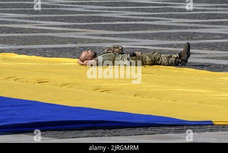 Kiev, Ucraina. 24th ago, 2022. Un soldato ucraino si trova sulla bandiera nazionale di Kyiv durante la Giornata dell'Indipendenza dell'Ucraina in mezzo all'invasione russa dell'Ucraina mercoledì 24 agosto 2022. Foto di Vladyslav Musienko /UPI Credit: UPI/Alamy Live News Foto Stock