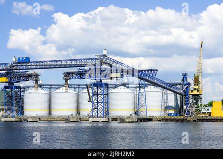 Terminale per grano versatile con molti silos di stoccaggio nel porto di Ventspils per il trasferimento di una vasta gamma e quantità di prodotti agricoli Foto Stock