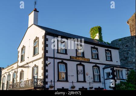 Caernarfon, Regno Unito - 10 luglio 2022: The Anglesey pub fuori dal muro medievale di Caernafon in Galles. Foto Stock