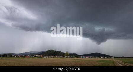 Tempesta distruttiva di supercelle che porta pioggia e vento sul campo agricolo Foto Stock