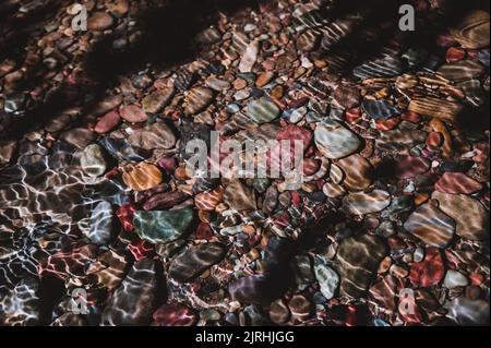 Arcobaleno rocce multicolore nel torrente delle valanghe che conduce verso il lago McDonald al Glacier National Park, Montana, USA Foto Stock