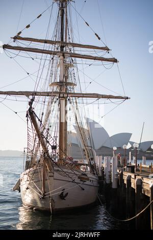 Una foto verticale di una nave a vela bianca su un porto con la Sydney Opera House sullo sfondo Foto Stock