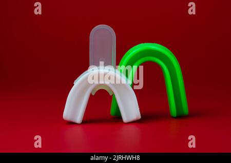 due protezioni in gomma per bocca, bianche e verdi, protezione per labbra e denti, concept Foto Stock