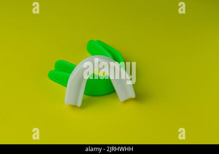 due protezioni in gomma per bocca, bianche e verdi, protezione per labbra e denti, concept Foto Stock