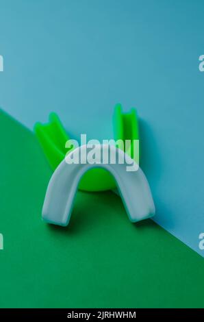 due protezioni in gomma per bocca, bianche e verdi, protezione per labbra e denti, concept Foto Stock