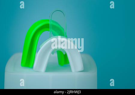 due protezioni in gomma per bocca, bianche e verdi, protezione per labbra e denti, concept Foto Stock