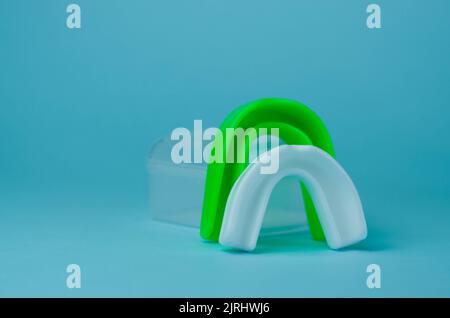 due protezioni in gomma per bocca, bianche e verdi, protezione per labbra e denti, concept Foto Stock