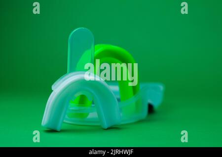 due protezioni in gomma per bocca, bianche e verdi, protezione per labbra e denti, concept Foto Stock