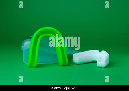 due protezioni in gomma per bocca, bianche e verdi, protezione per labbra e denti, concept Foto Stock