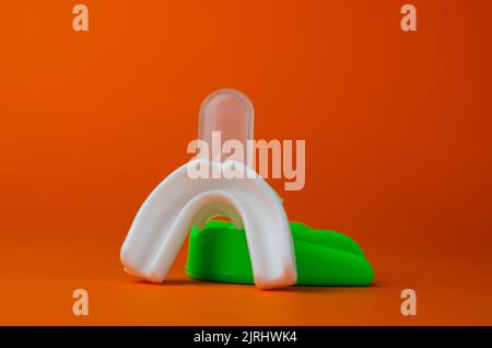 due protezioni in gomma per bocca, bianche e verdi, protezione per labbra e denti, concept Foto Stock