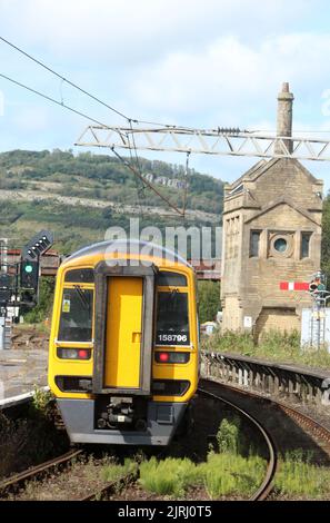 I treni del Nord esprimono il treno sprinter dmu che parte dalla stazione di Carnforth il 24th agosto 2022, segnale di piuma alla fine della piattaforma con erbacce in pista-letto. Foto Stock