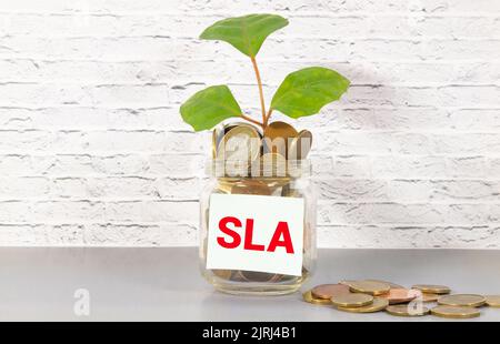 Business Concept - parola SLA scritta su un foglio di appunti su sfondo nero. sla abbreviazione di Service Level Agreement Foto Stock