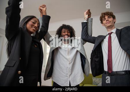 Felice gruppo multietnico di affari che festeggia in ufficio, pietra miliare aziendale Foto Stock