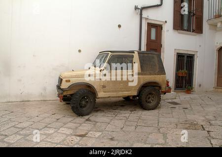 Un veicolo fuoristrada fangoso parcheggiato su una strada cittadina in Italia Foto Stock