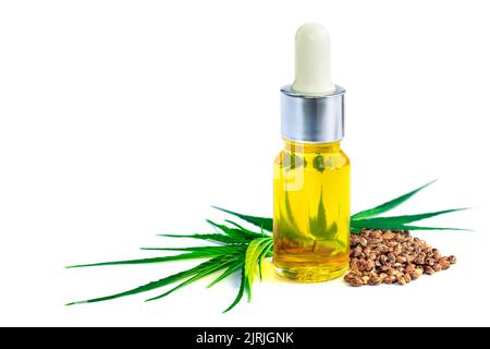 Bottiglia con olio di canapa, foglie di canapa e semi su fondo bianco, prodotti di canapa in olio CBD, olio di estratto di cannabis, marijuana medica. Foto Stock