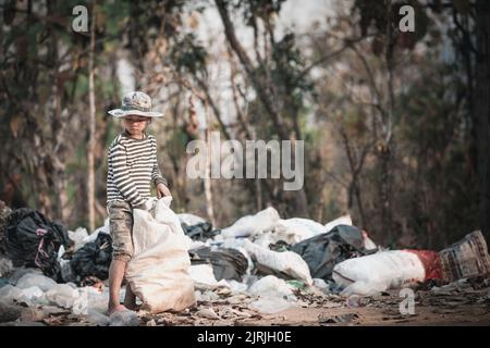 I bambini poveri raccolgono rifiuti per la vendita a causa della povertà, riciclaggio della spazzatura, lavoro minorile, concetto di povertà, Giornata mondiale dell'ambiente, Foto Stock