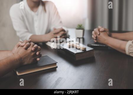 Concetto cristiano. Mettete le mani sulla Bibbia e pregate Dio. Studia la Bibbia insieme. Vivere la vita. Pregare insieme. Combinando il potere della speranza o. Foto Stock