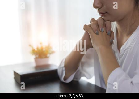 le mani della donna pregano dio con la bibbia. Donna prega per la benedizione di dio. Credenze religiose vita cristiana crisi preghiera a dio. Foto Stock