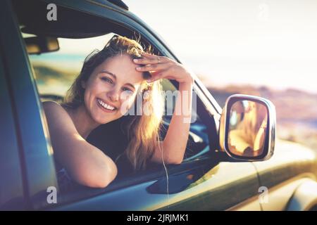 Felicità destinazione. Ritratto ritagliato di una giovane donna attraente su un viaggio in auto. Foto Stock