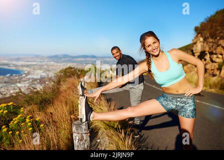 Allungandosi per rinforzare il corpo. Ritratto di una giovane coppia sportiva che si allunga prima di una corsa all'aperto. Foto Stock