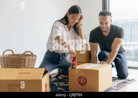 Giovane coppia con grande scatola nella loro nuova casa, portando le cose in una nuova casa. Foto Stock