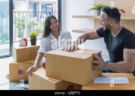 Giovane coppia con grande scatola nella loro nuova casa, portando le cose in una nuova casa. Foto Stock