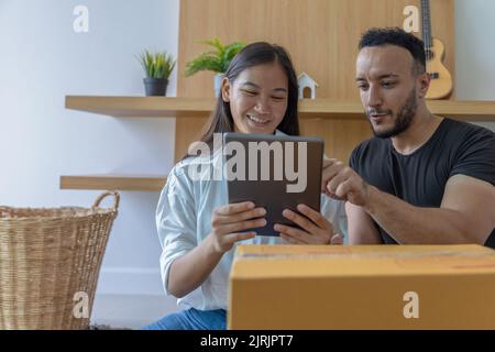 Giovane coppia con grande scatola nella loro nuova casa, portando le cose in una nuova casa. Foto Stock