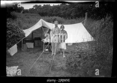 [Coppia in piedi di fronte a una tenda], 1920s a 1930s, di Roland Searle. Foto Stock