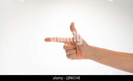 il gesto della mano della donna ripiegato come una pistola isolata su uno sfondo bianco. Foto di alta qualità Foto Stock