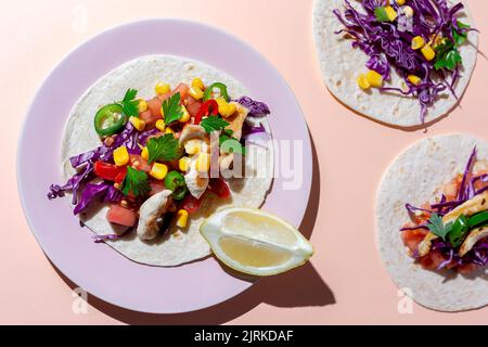 Tacos messicani fatti in casa con verdure fresche e pollo con forte luce su sfondo rosa. Cibo sano. Tipico messicano Foto Stock