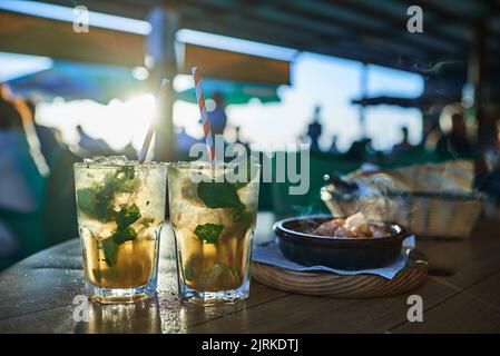 Bicchieri di gustose bevande rinfrescanti con fette di limone e foglie di menta fresca su cubetti di ghiaccio nella caffetteria di Fuerteventura Spagna Foto Stock
