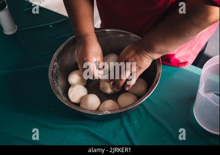 Dall'alto del raccolto irriconoscibile etnico femmina preparare impasto morbido in ciotola a tavola in cucina Foto Stock